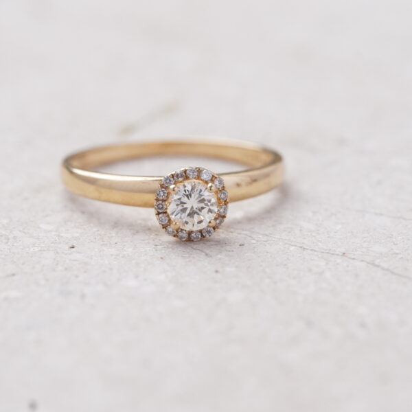 Anillo solitario diamante central de 0.25CT con bisel de diamantes en oro amarillo