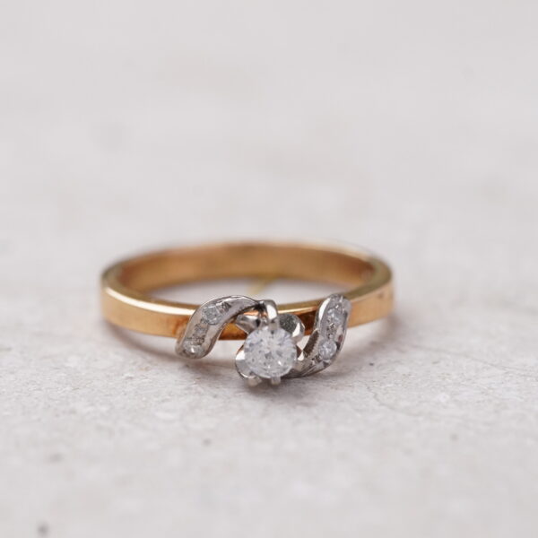 Diamante central de 0.10CT en oro amarillo con entrelazado en oro blanco y diamantes